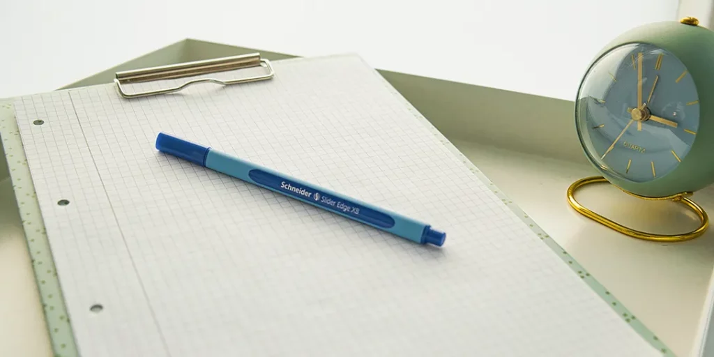 Ein Klemmbrett mit einem Formular und einem Stift für Klienten, um Anmeldeformulare oder Fragebögen vor einer Sitzung auszufüllen.