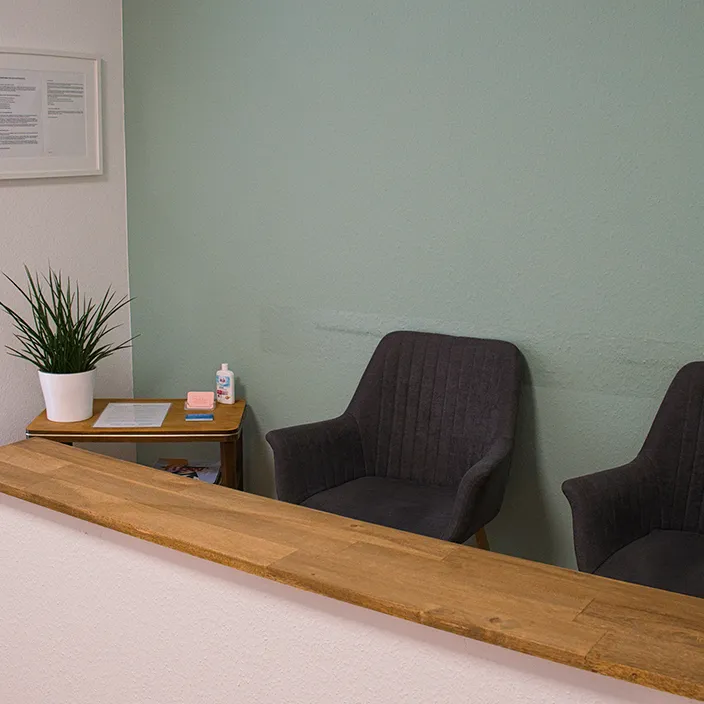 Ein einladender, moderner Wartebereich mit bequemen Sitzgelegenheiten, Zeitschriften und einer warmen Atmosphäre für Klienten.